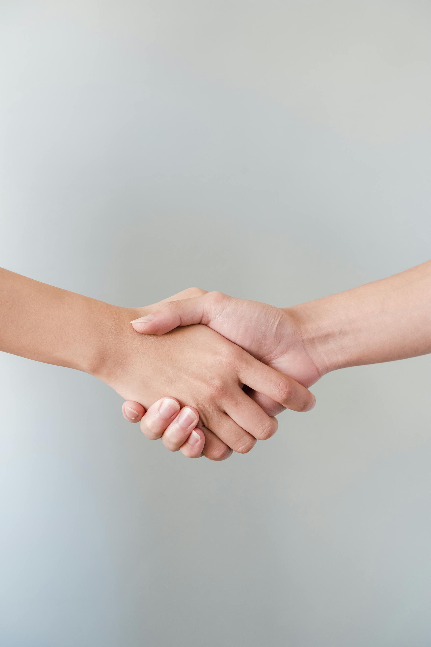 A detailed view of a handshake between two individuals, symbolizing agreement and collaboration.